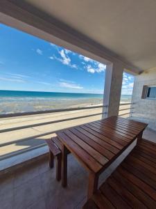 a wooden table on a balcony with a view of the beach at Nuevos Aires in Las Grutas