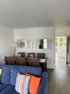 a living room with a blue couch and a table at Lakefront Lodge w SUP & Fishing Access Cotswolds in Gloucestershire