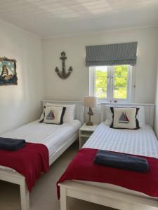 two beds in a white room with a window at Lakefront Lodge w SUP & Fishing Access Cotswolds in Gloucestershire