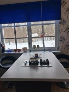 a kitchen with a table and two large windows at Kihulase maja in Luigu