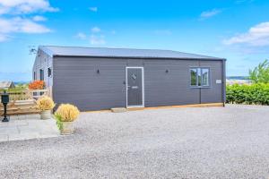 a gray building with a door on a gravel driveway at 2 Bed in Somerton oc-s32606 in Somerton