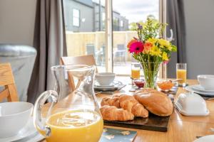a table with bread and a jug of orange juice and flowers at 2 Bed in Somerton oc-s32606 in Somerton +8 photos