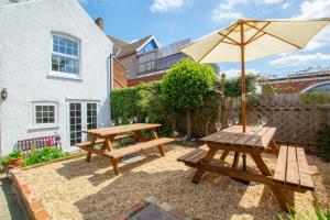 a picnic table and an umbrella in front of a house at 6 Bed in Cromer oc-1996 in Cromer