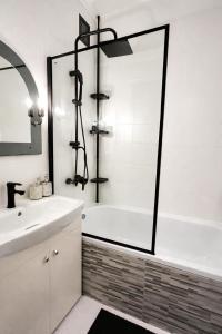 a white bathroom with a tub and a sink at Apartman Cañas Modrá Víla in Rimavská Sobota