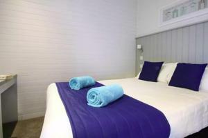 a bedroom with a bed with blue towels on it at Forest Edge 4 Bedroom Select Lodge in Saint Leonards