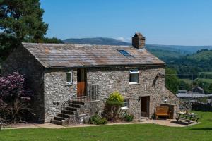 an old stone house with a bench and a table at 2 Bed in Low Row oc-ds1010 in Gunnerside