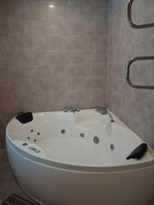 a large white bath tub in a bathroom at Kihulase maja in Luigu +12 photos