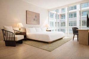 a bedroom with a white bed and a chair at Nester Finn Entertainment District in Toronto
