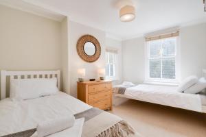 a white bedroom with two beds and a mirror at 3 Bed in St. Ives oc-marhou in St Ives