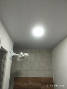 a bathroom with a shower with a light on the ceiling at Suíte 2 Itaguaí in Itaguaí