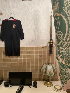 a black shirt hanging on a wall next to a laptop at Aux cieux enchanteurs maison magique et spa in Hondschoote +20 photos
