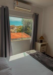 a bedroom with a bed and a large window at Pousada Casa de Praia in Marechal Deodoro +23 photos