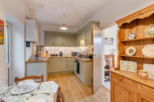 a kitchen with green cabinets and a table and a dining room at 2 Bed in Ingleton oc-w31066 in Ingleton