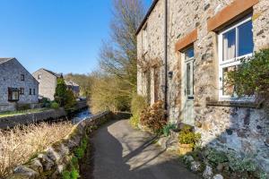 a stone house with a walkway next to a river at 2 Bed in Ingleton oc-w31066 in Ingleton