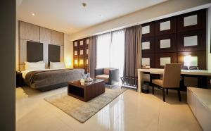 ein Hotelzimmer mit Bett und Schreibtisch in der Unterkunft The Wheatbaker in Lagos