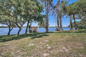 a house on the shore of a lake with trees at Charming Lakefront Apt Near Disney in Orlando +12 photos