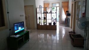 a living room with a flat screen tv and a tv stand at Homey House Serpong in Serpong