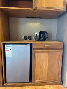a small kitchen with a counter and a refrigerator at Capri Hills in Mwanza +3 photos