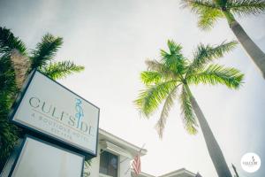 a sign for a hotel with palm trees in the background at Gulfside Resort. Unit 10 in St. Pete Beach