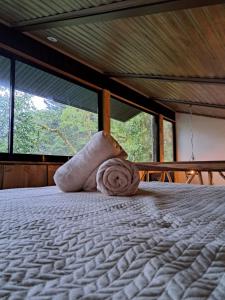 a room with a bed with a rolled up towel at Casa Tucan Glamping in Turrialba