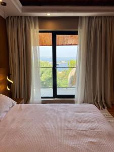 a bedroom with a bed and a large window at Capri Hills in Mwanza