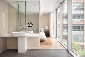 a bathroom with a white sink and a bedroom at Nester Finn Entertainment District in Toronto