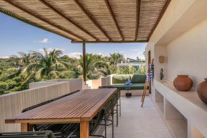 an outdoor patio with a wooden table and chairs at Condominios Punta Morelos in Brisas de Zicatela