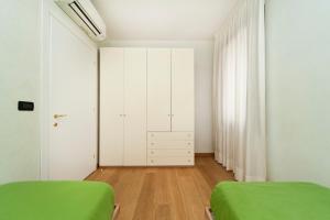 1 dormitorio con 2 camas verdes y armarios blancos en Rialto Franklin, en Venecia