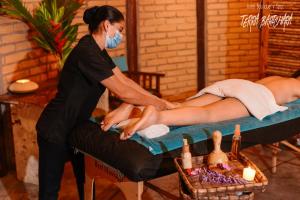 a woman giving a woman a massage on a bed at Hotel Terra Barichara in Barichara +59 photos