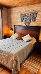 a bedroom with a large bed with a wooden wall at Rümü in Pucón +56 photos