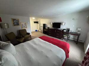 a hotel room with a bed and a desk and a television at Mon Joli Motel in Sainte-Flavie