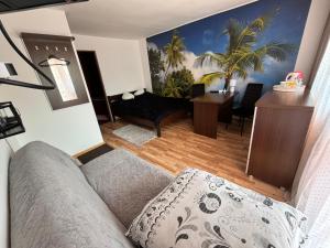 a living room with a couch and a palm tree mural at Abba -pokoje wakacyjne in Wisła