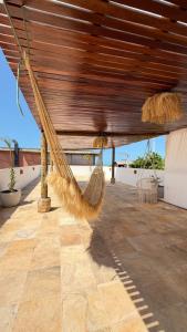 a hammock with hay hanging from a roof at Pousada Vila Didi - Flats com Cozinha Completa in Barra Grande