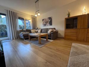 a living room with a couch and a coffee table at Wagner Apartment Bayreuth FeWo - Erdgeschoss - nähe Festspielhaus - Free-WiFi - Schlafzimmer - Boxspringbetten - große Küche - Dusche - Badewanne - extra WC - Terrasse - DTV-Zertifiziert in Bayreuth