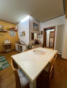 a dining room with a white table and chairs at Casa Marisa in Monteviale