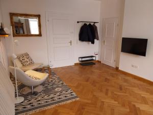 a living room with a chair and a television at Königliche Villa - Watzmannblick - nahe Zentrum und Bahnhof in Berchtesgaden