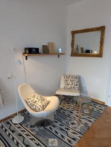 a living room with a chair and a mirror at Königliche Villa - Watzmannblick - nahe Zentrum und Bahnhof in Berchtesgaden