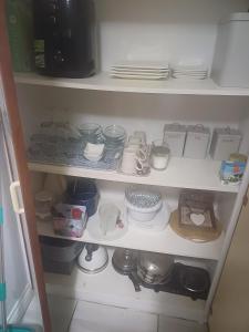 a kitchen pantry with dishes and plates on shelves at Liza's Retreat in Mossel Bay