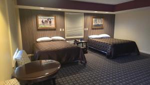 a hotel room with two beds and a table at Classic Inn Lancaster in Lancaster