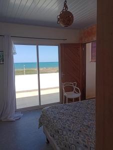 a bedroom with a bed and a view of the beach at Casa da barra in Canguaretama