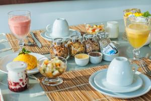 a table topped with plates and glasses of food and drinks at Casa Makaira in Fernando de Noronha