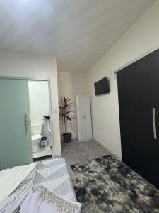 a bedroom with a bed and a mirror and a bathroom at Hotel ph in Barcarena
