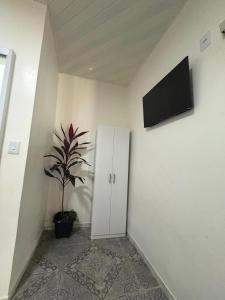 a room with a white cabinet and a potted plant at Hotel ph in Barcarena