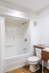 a bathroom with a toilet and a tub and a sink at Mon Joli Motel in Sainte-Flavie +17 photos