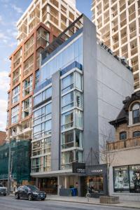 a large glass building with a car parked in front of it at Nester Finn Entertainment District in Toronto