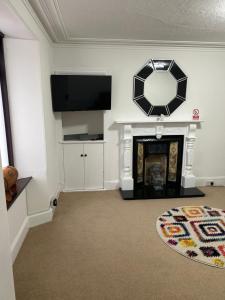 a living room with a fireplace and a mirror at Mortlach Cottage in Dufftown