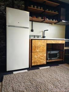 a kitchen with a refrigerator and a microwave at Jim3 moterno studio fast wi-fi with a view in Andravída