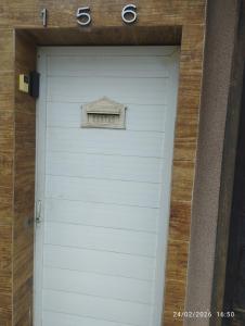 a white garage door with a sign above it at Suíte 2 Itaguaí in Itaguaí