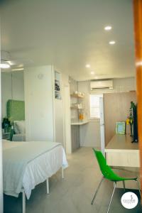 a bedroom with a bed and a green chair at Gulfside Resort. Unit 6 in St. Pete Beach