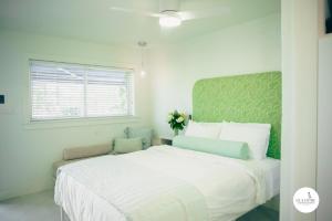 a white bedroom with a large white bed and a window at Gulfside Resort. Unit 6 in St. Pete Beach